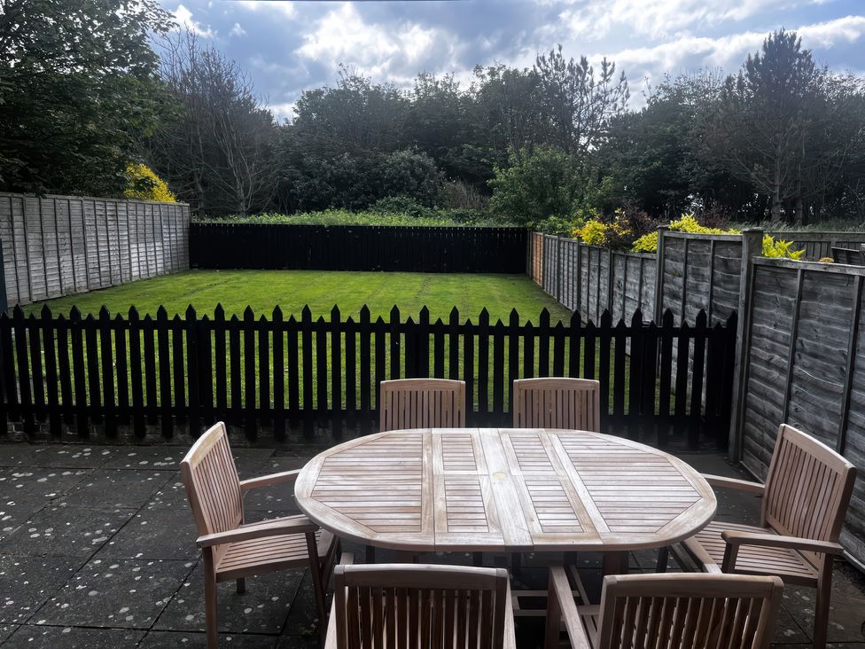 A garden with a table and chairs at Glenavon in Seahouses