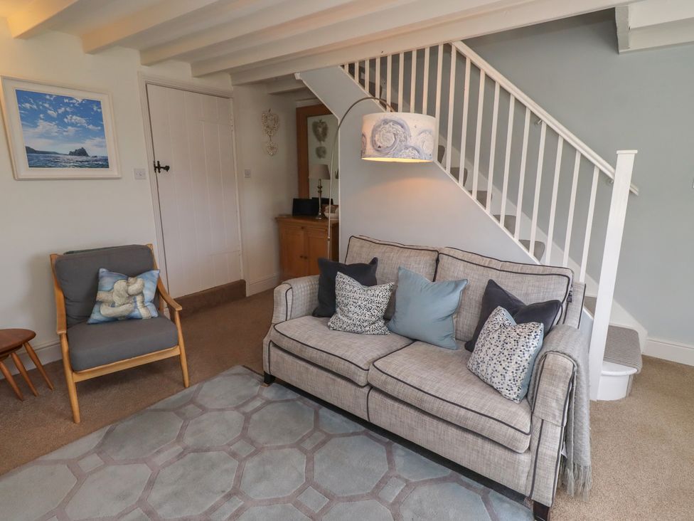 A living room with a sofa and armchair at Marie's Cottage in Craster
