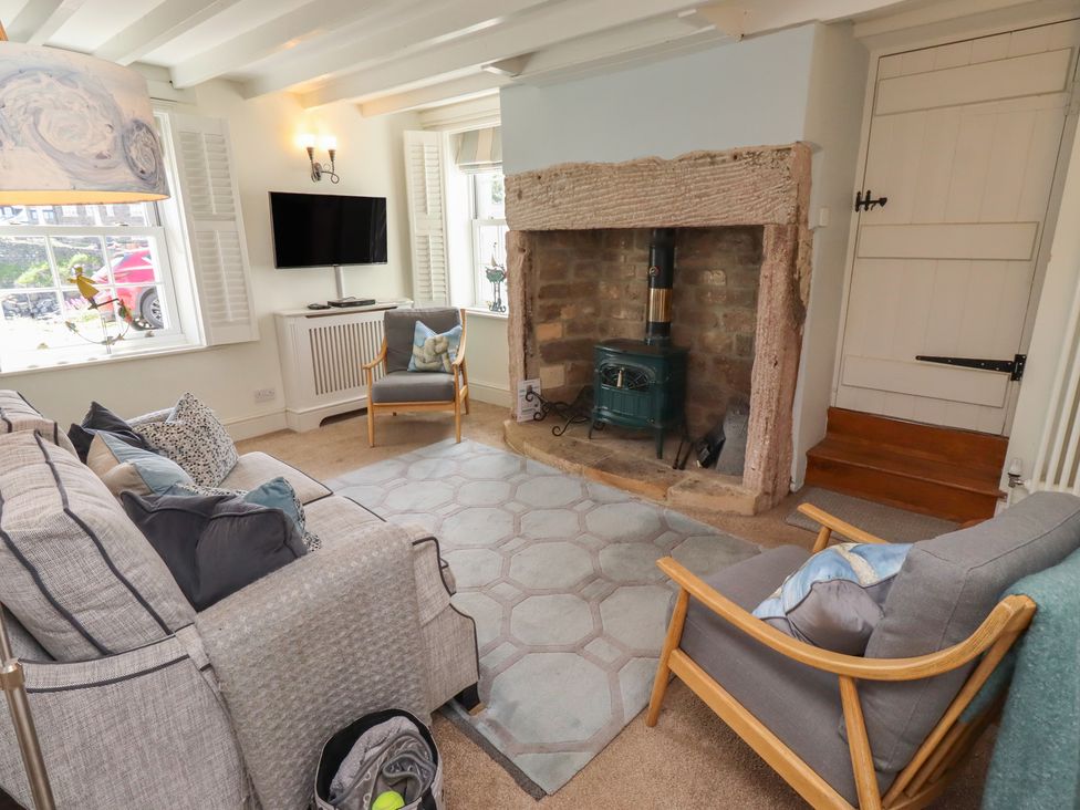 A living room with a sofa and television at Marie's Cottage in Craster