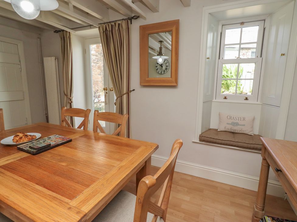 A dining room with a table and chairs at Marie's Cottage in Craster