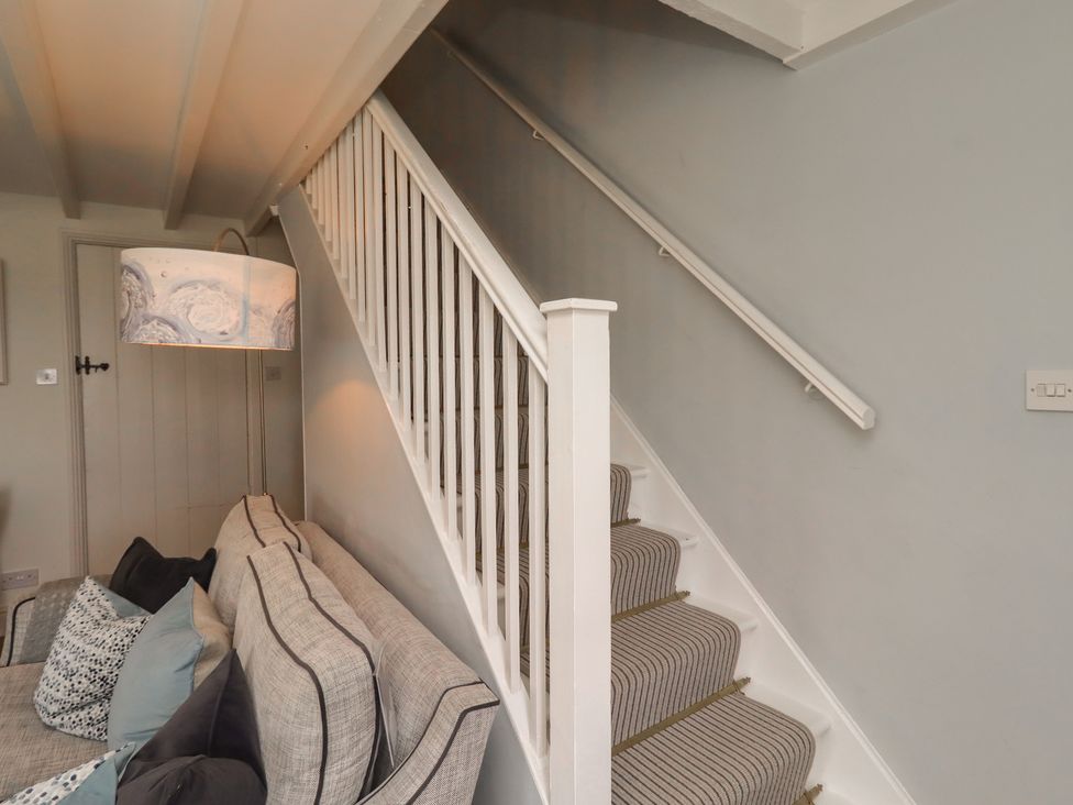 A staircase leading to the upper floor from the living room at Marie's Cottage in Craster