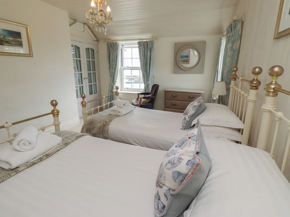 A bedroom with twin beds and a dresser at Marie's Cottage in Craster