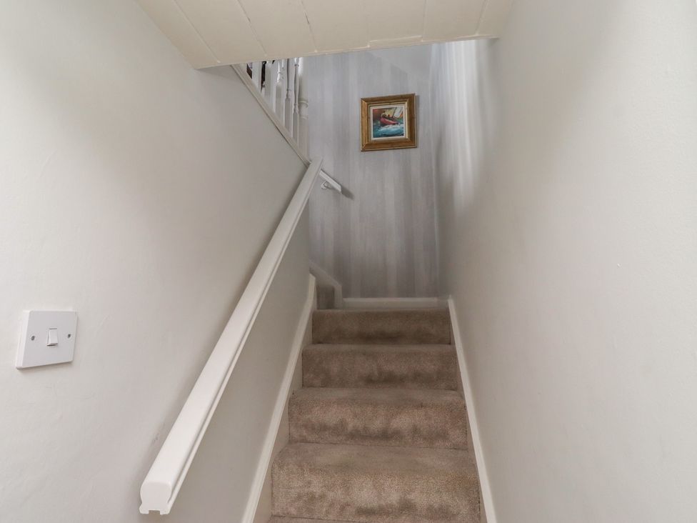 Stairs with handrail and painting at Marie's Cottage in Craster