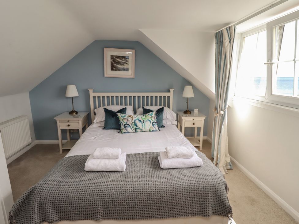 A bedroom with a bed and bedside tables at Marie's Cottage in Craster
