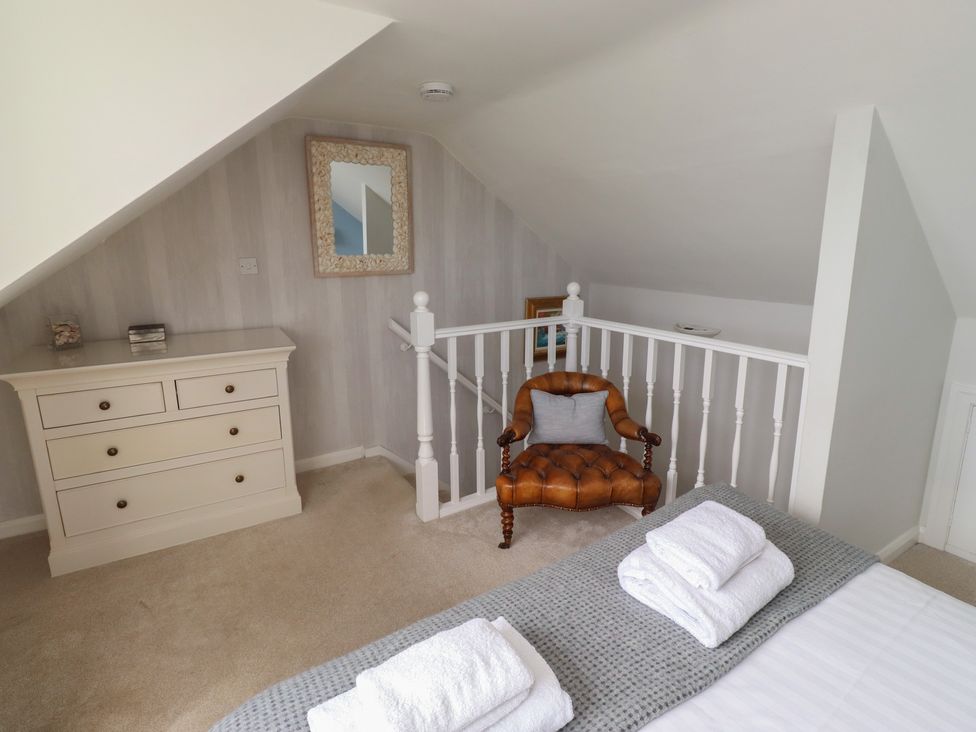 A bedroom with a bed and a dressing table at Marie's Cottage in Craster