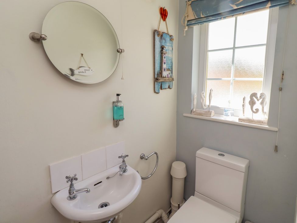 A bathroom with a sink and toilet at Marie's Cottage in Craster