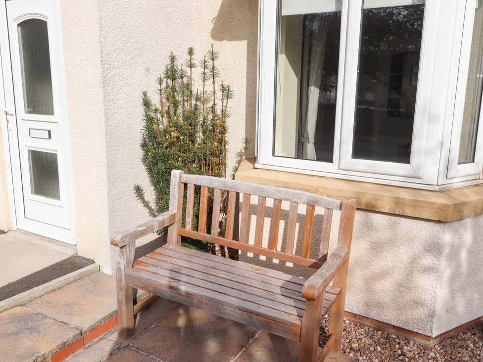A bench beside a door and window at Beach View in Seahouses