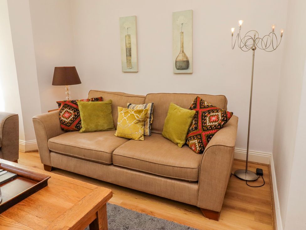 A living room with a sofa and cushions at Alnbank in Alnmouth