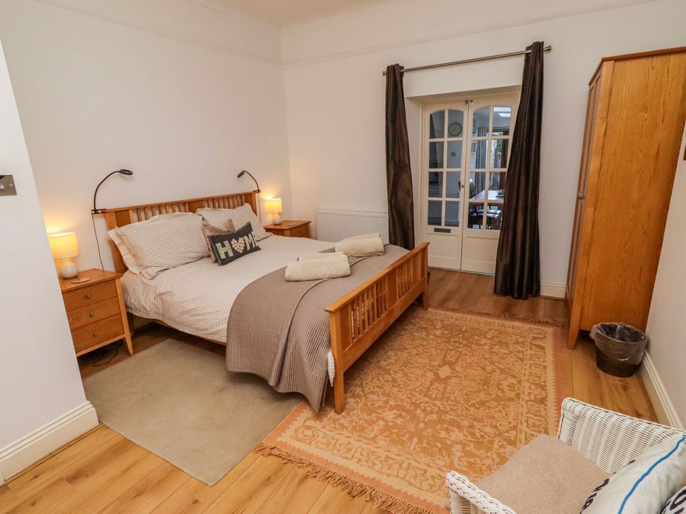 A bedroom with a bed, bedside tables and a wardrobe at Alnbank in Alnmouth