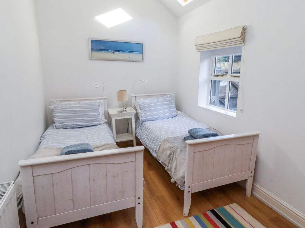 A bedroom with two single beds and a bedside table at Alnbank in Alnmouth