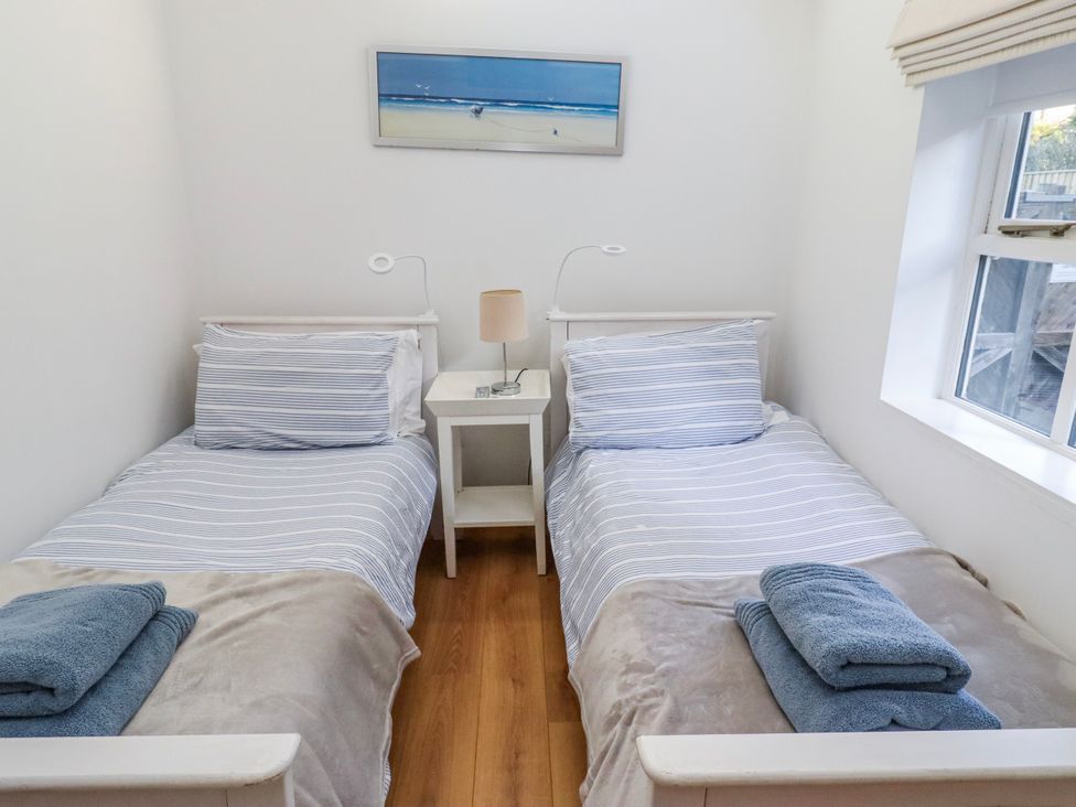 A bedroom with two beds and a bedside table at Alnbank in Alnmouth