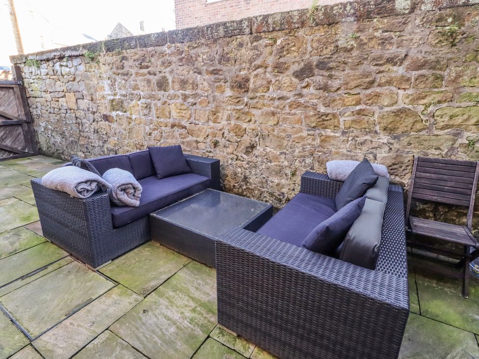 An outdoor seating area with sofas, a table, and a chair at Alnbank in Alnmouth
