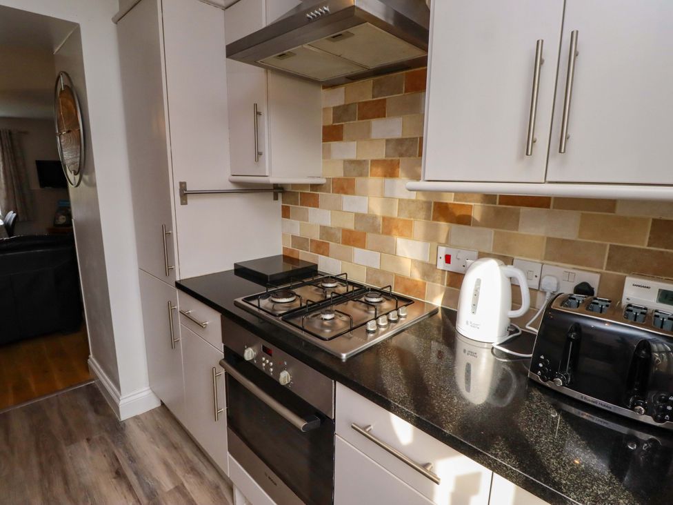 A kitchen with a gas stove and kettle at Heather Cottages - Brent Goose, Bamburgh