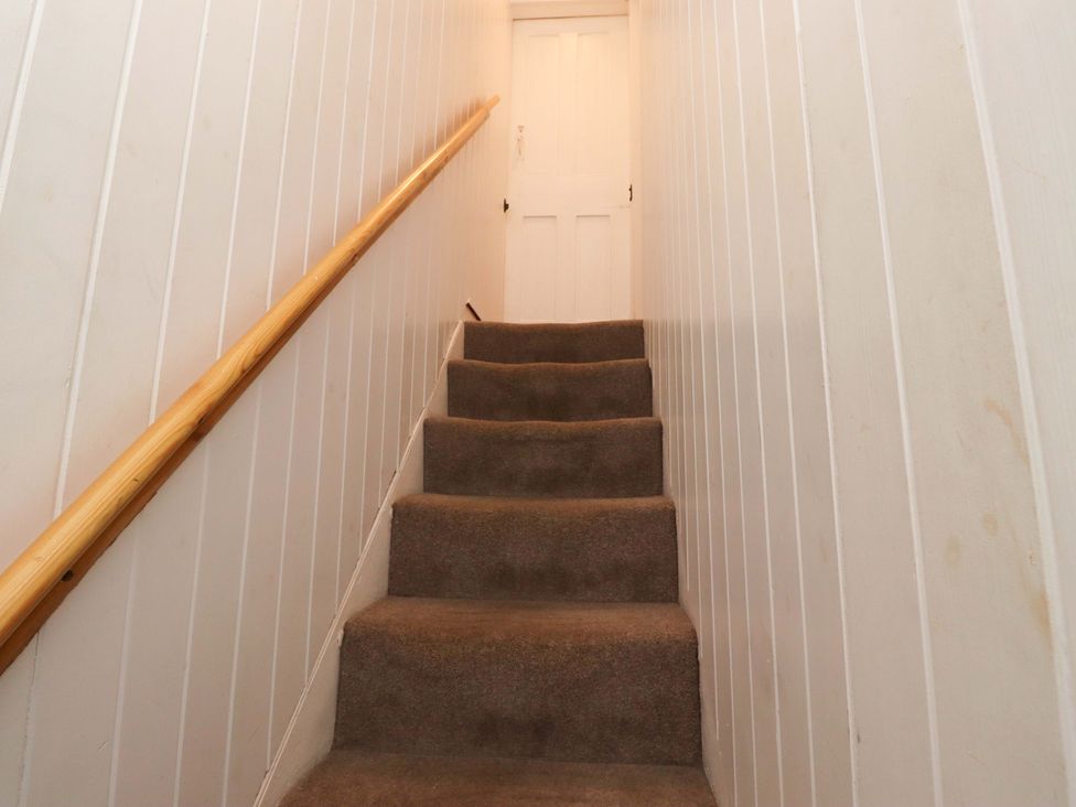 A stairway leading to a door at Heather Cottages - Brent Goose in Bamburgh