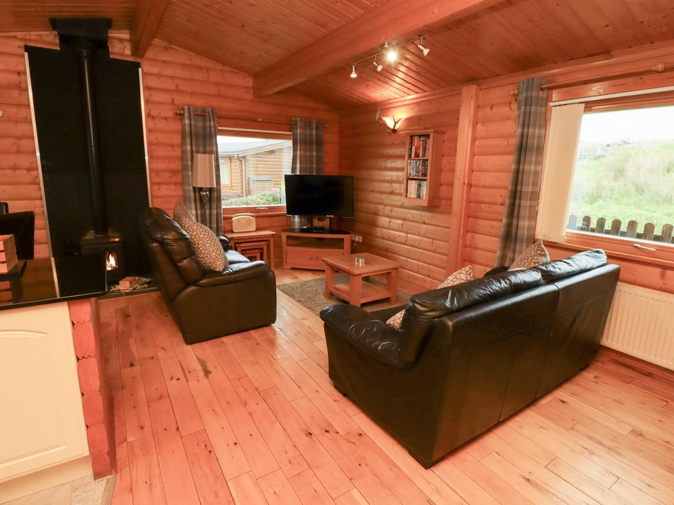 A living room with a sofa and television at Heather Cottages - Brown Owl Bamburgh