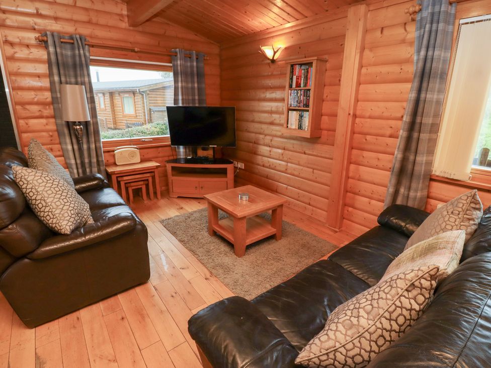 A living room with a TV and coffee table at Heather Cottages - Brown Owl in Bamburgh