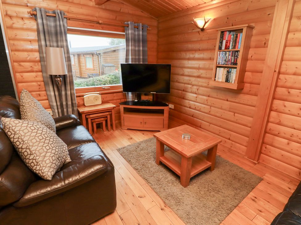 A living room with a television and coffee table at Heather Cottages - Brown Owl in Bamburgh