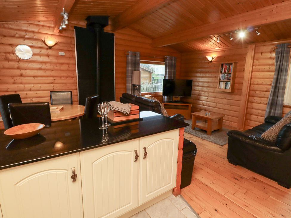 A living room with a television and seating area at Heather Cottages - Brown Owl in Bamburgh