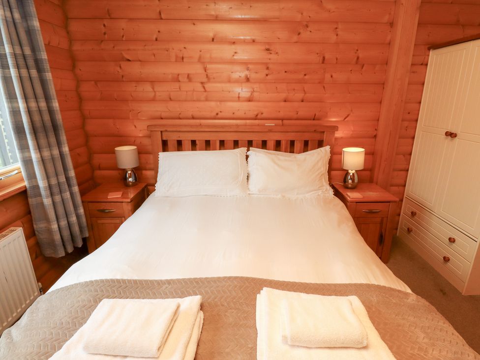 A bedroom with a double bed and nightstands at Heather Cottages - Brown Owl in Bamburgh