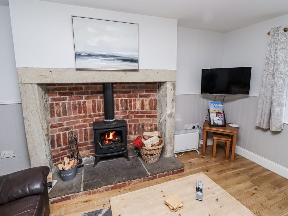A living room with a fireplace and television at Heather Cottages - Godwit in Bamburgh