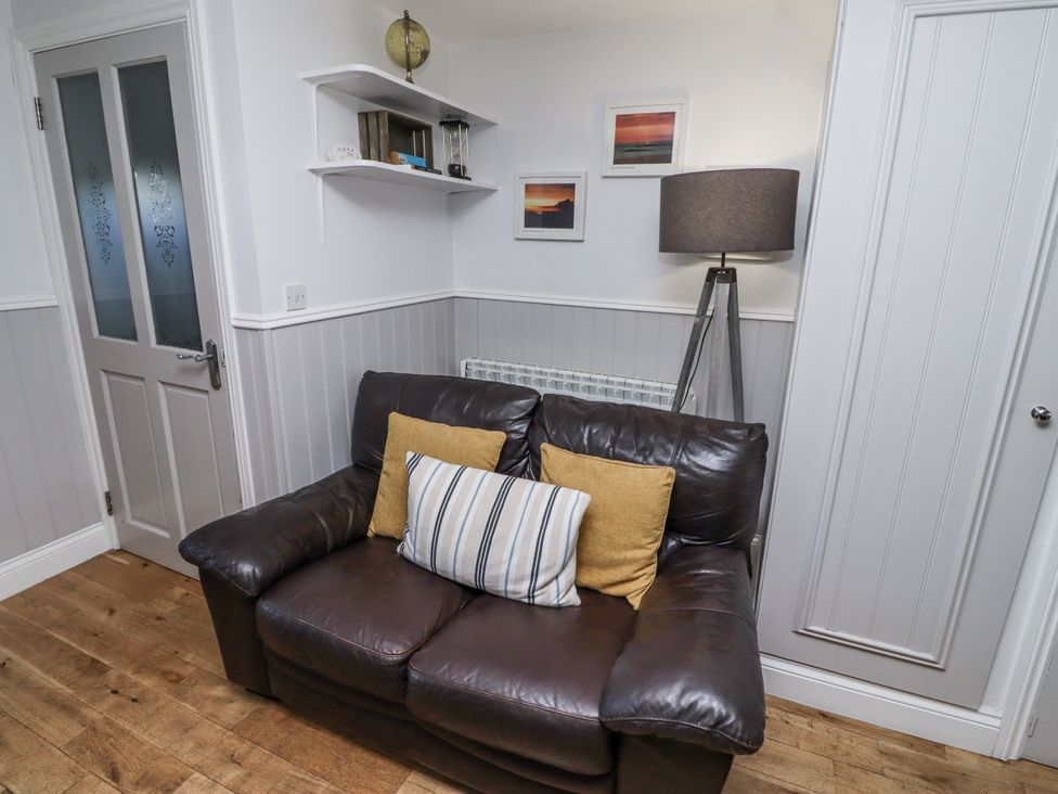 A living room with a sofa and a shelf at Heather Cottages - Godwit in Bamburgh