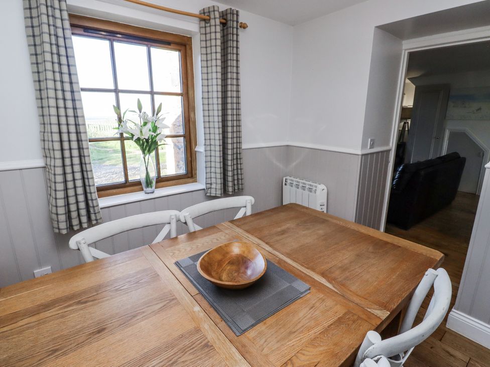 A dining room with a table and chairs at Heather Cottages - Godwit in Bamburgh