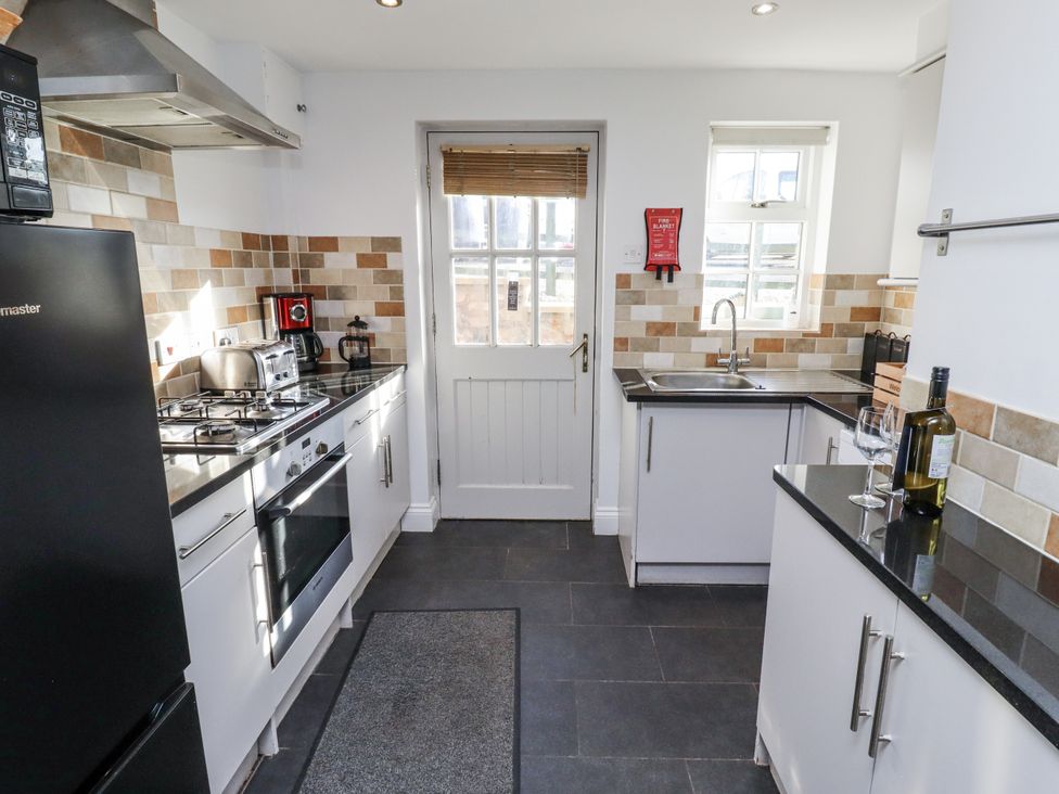 A kitchen with appliances and counter space at Heather Cottages - Godwit Bamburgh