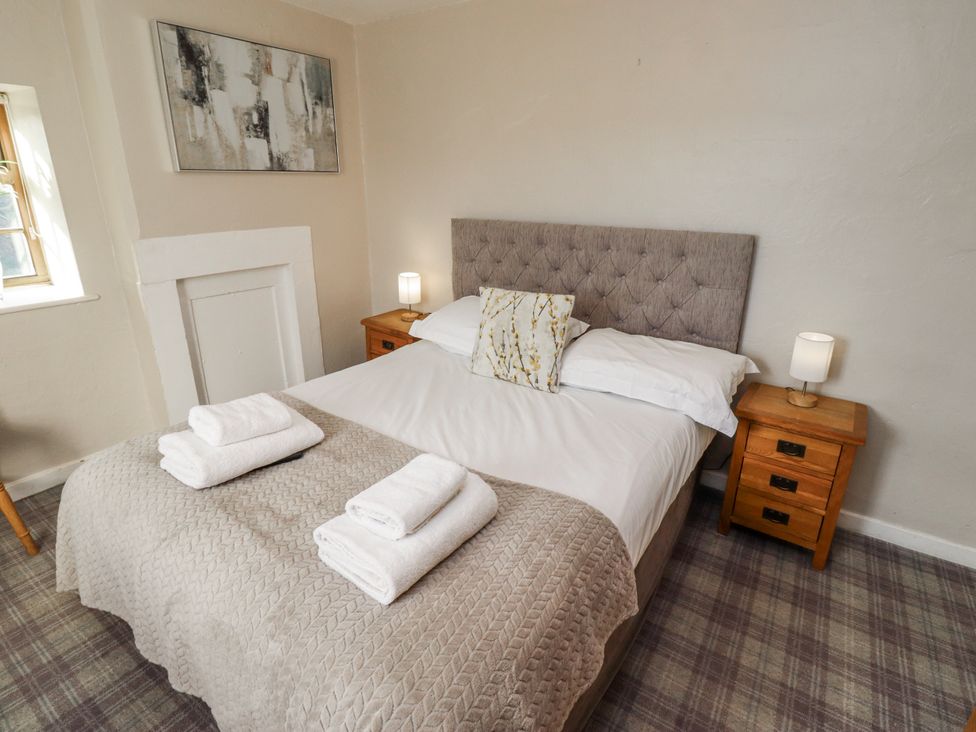 A bedroom with a bed and bedside tables at Heather Cottages - Godwit in Bamburgh