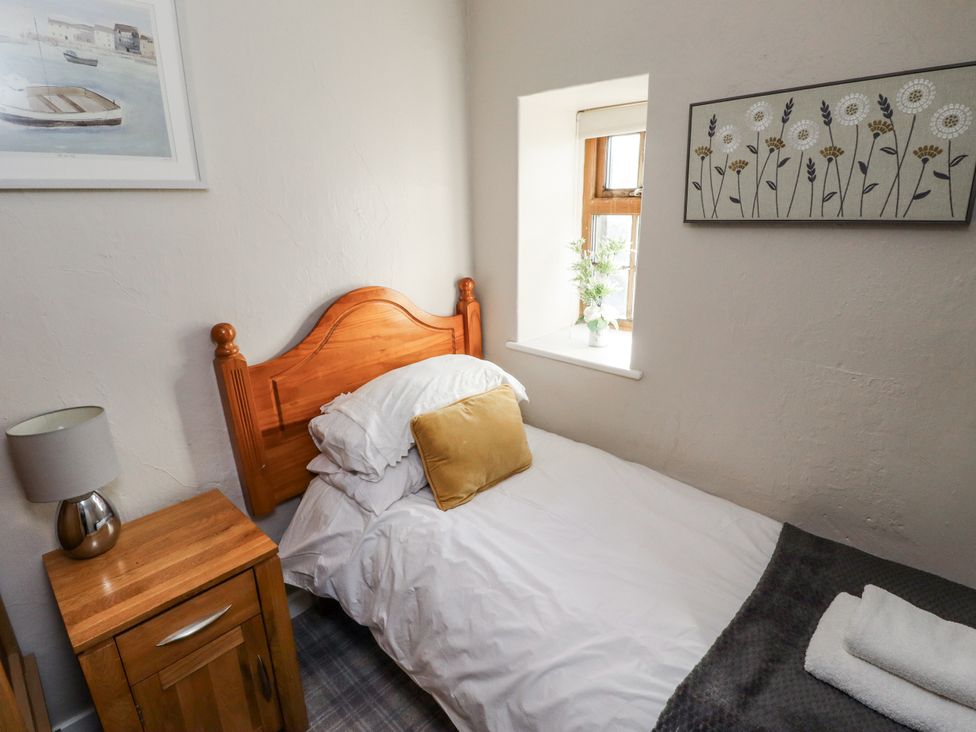 A bedroom with a bed and nightstand at Heather Cottages - Godwit in Bamburgh