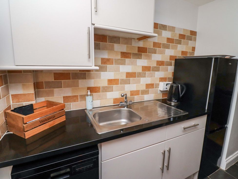 A kitchen with a sink and refrigerator at Heather Cottages - Grayling Bamburgh