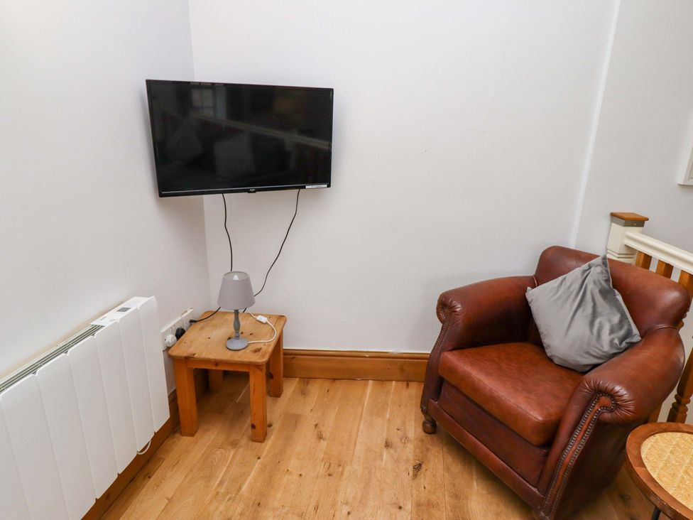 A living room with a television and armchair at Heather Cottages - Grey Seal in Bamburgh