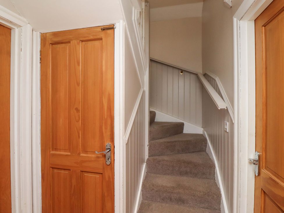 A staircase leading to upstairs in a hallway at Heather Cottages - Grey Seal in Bamburgh