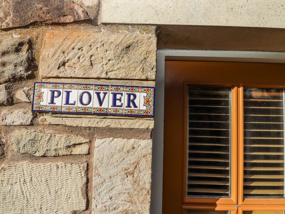 A nameplate on a stone wall at Heather Cottages - Plover in Bamburgh