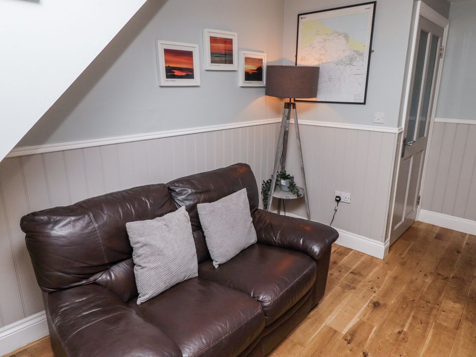 A living room with a sofa and lamp at Heather Cottages - Plover in Bamburgh