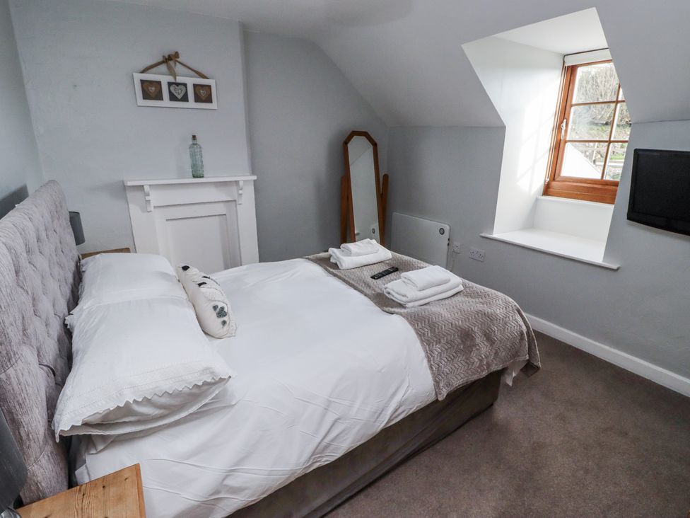 A bedroom with a bed and a window at Heather Cottages - Plover in Bamburgh