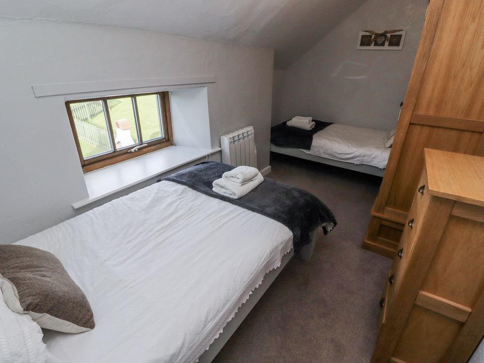 A bedroom with two beds and a window at Heather Cottages - Plover in Bamburgh