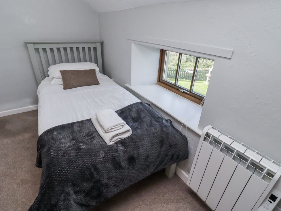 A bedroom with a single bed and a window at Heather Cottages - Plover in Bamburgh