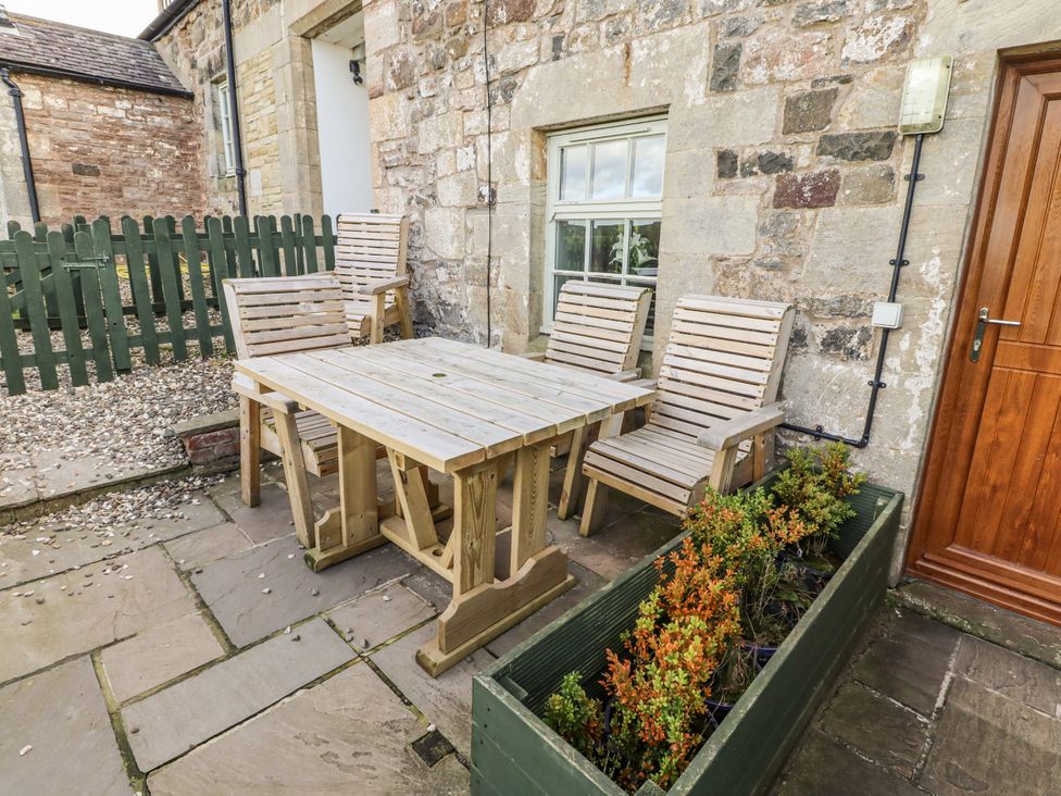 An outdoor seating area with a table and chairs at Heather Cottages - Plover in Bamburgh