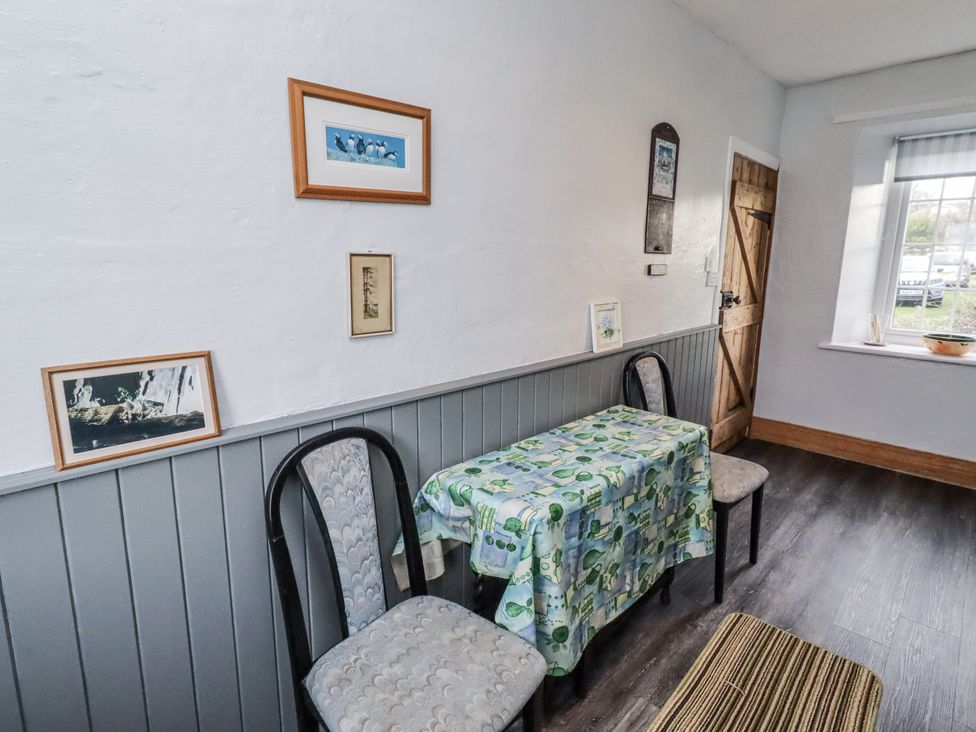 A dining area with a table and chairs at Kittiwake Cottage, Budle Bay