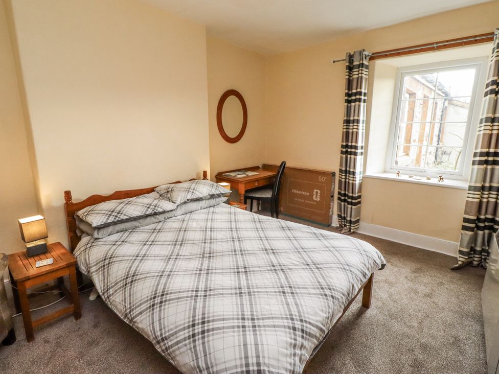 A bedroom with a bed and desk at Kittiwake Cottage, Budle Bay Bamburgh