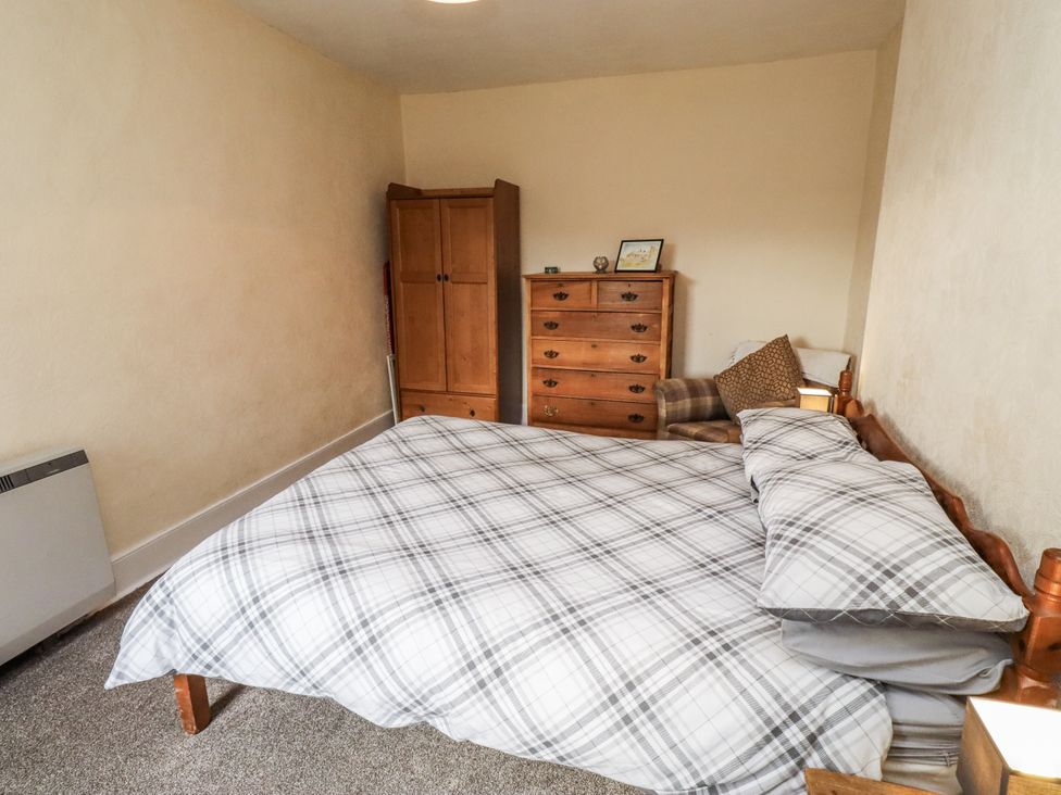 A bedroom with a bed and furniture at Kittiwake Cottage, Budle Bay