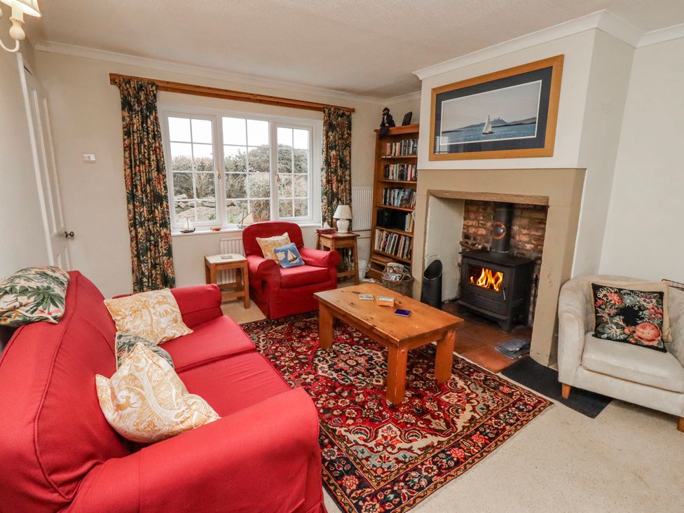 A living room with a sofa, armchair, coffee table and fireplace at St Marys Cottages No4 in Low Newton-by-the-Sea