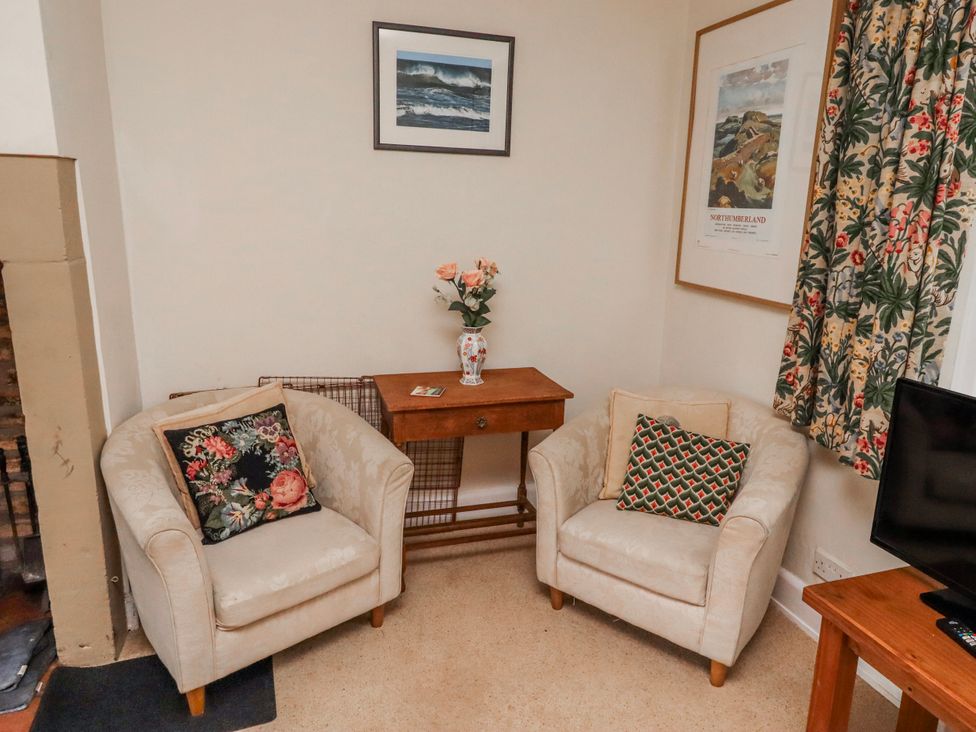 A living room with armchairs and a side table at St Marys Cottages No4 Low Newton-by-the-Sea