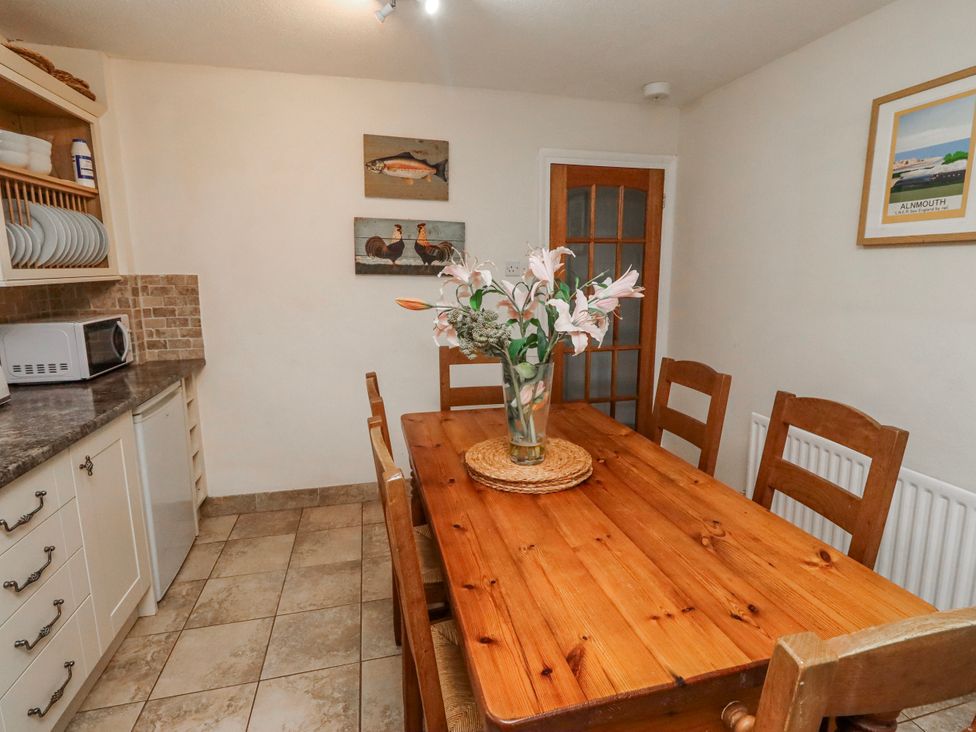 A dining room with a table and chairs at St Marys Cottages No4 in Low Newton-by-the-Sea