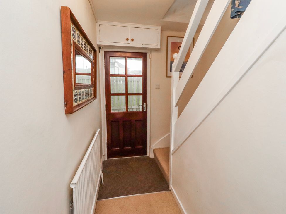 A hallway with a door and a staircase at St Marys Cottages No4 Low Newton-by-the-Sea