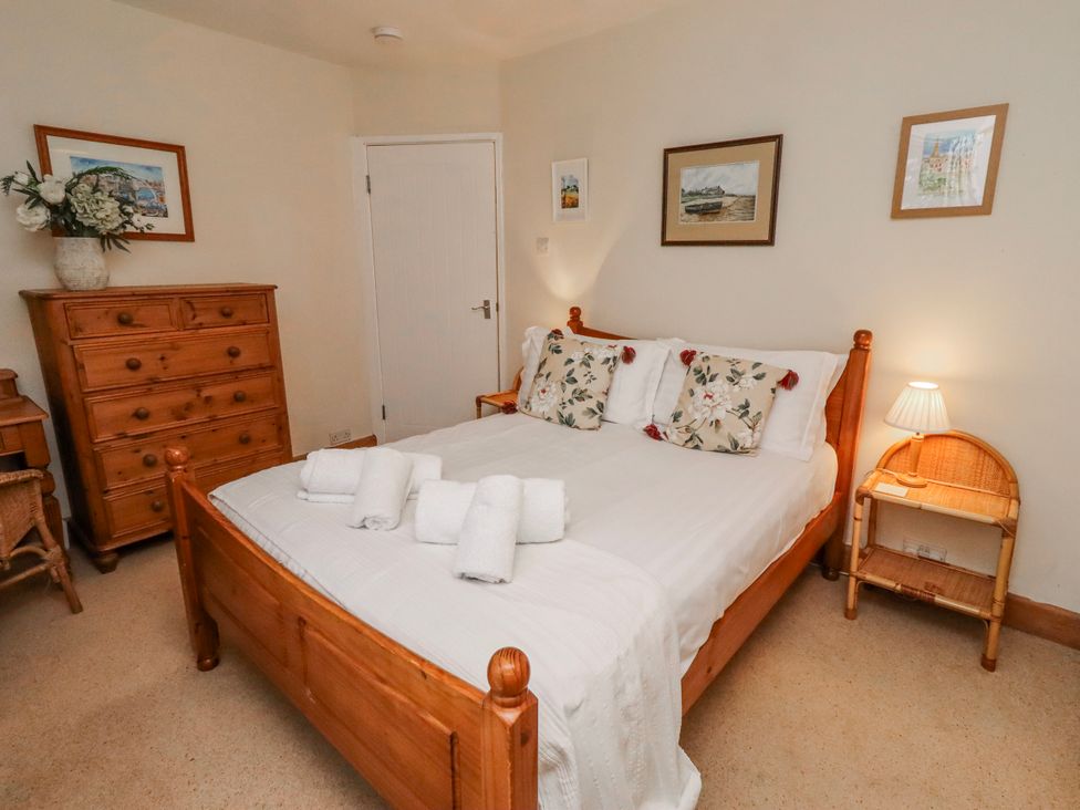 A bedroom with a bed and a dresser at St Marys Cottages No4 Low Newton-by-the-Sea