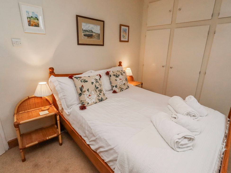 A bedroom with a bed and bedside table at St Marys Cottages No4 Low Newton-by-the-Sea