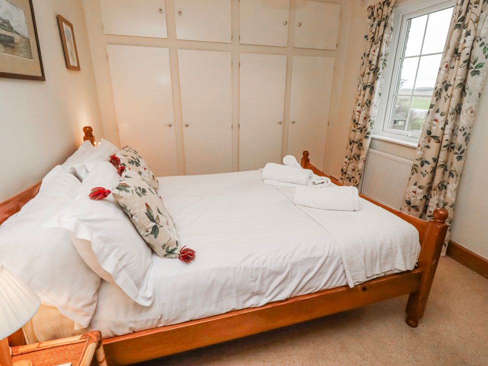 A bedroom with a bed and wardrobe at St Marys Cottages No4 Low Newton-by-the-Sea