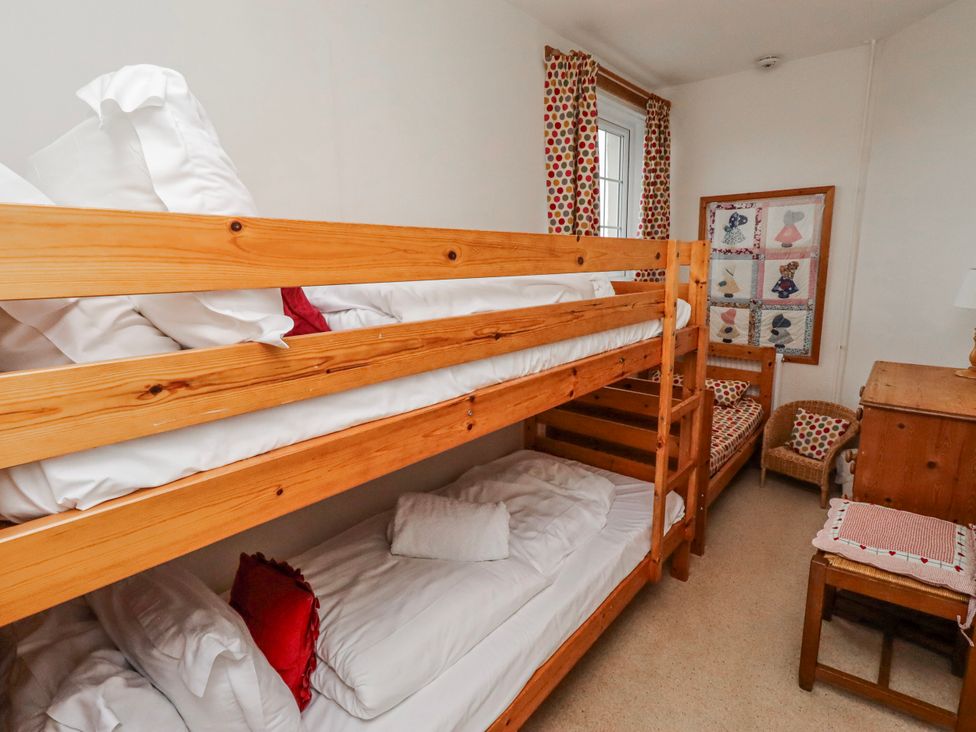 A bedroom with bunk beds and a single bed at St Marys Cottages No4 in Low Newton-by-the-Sea