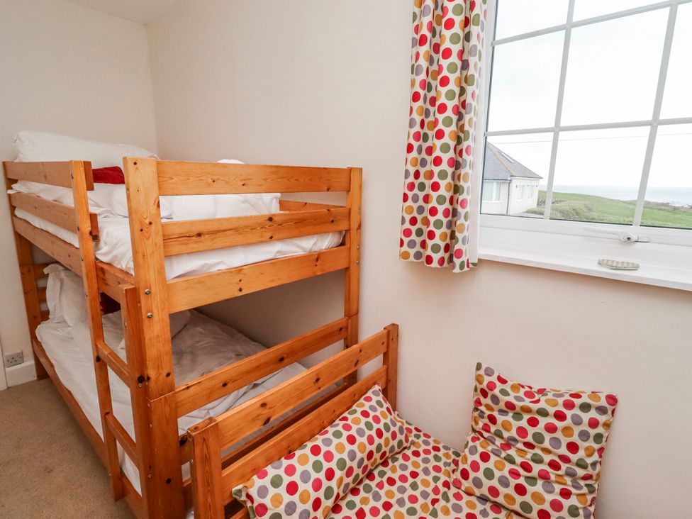 A bedroom with a bunk bed and cushions at St Marys Cottages No4 Low Newton-by-the-Sea